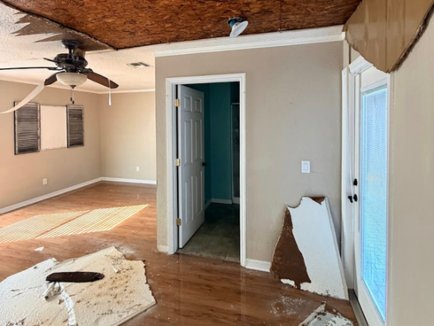 Interior room with severe ceiling damage from water intrusion, showing large sections of drywall removed