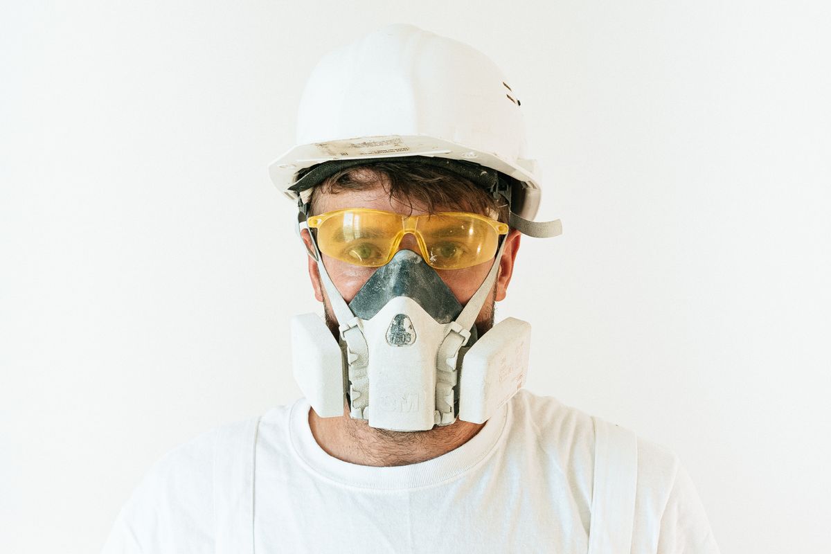 Worker wearing a respirator mask and PPE for asbestos abatement